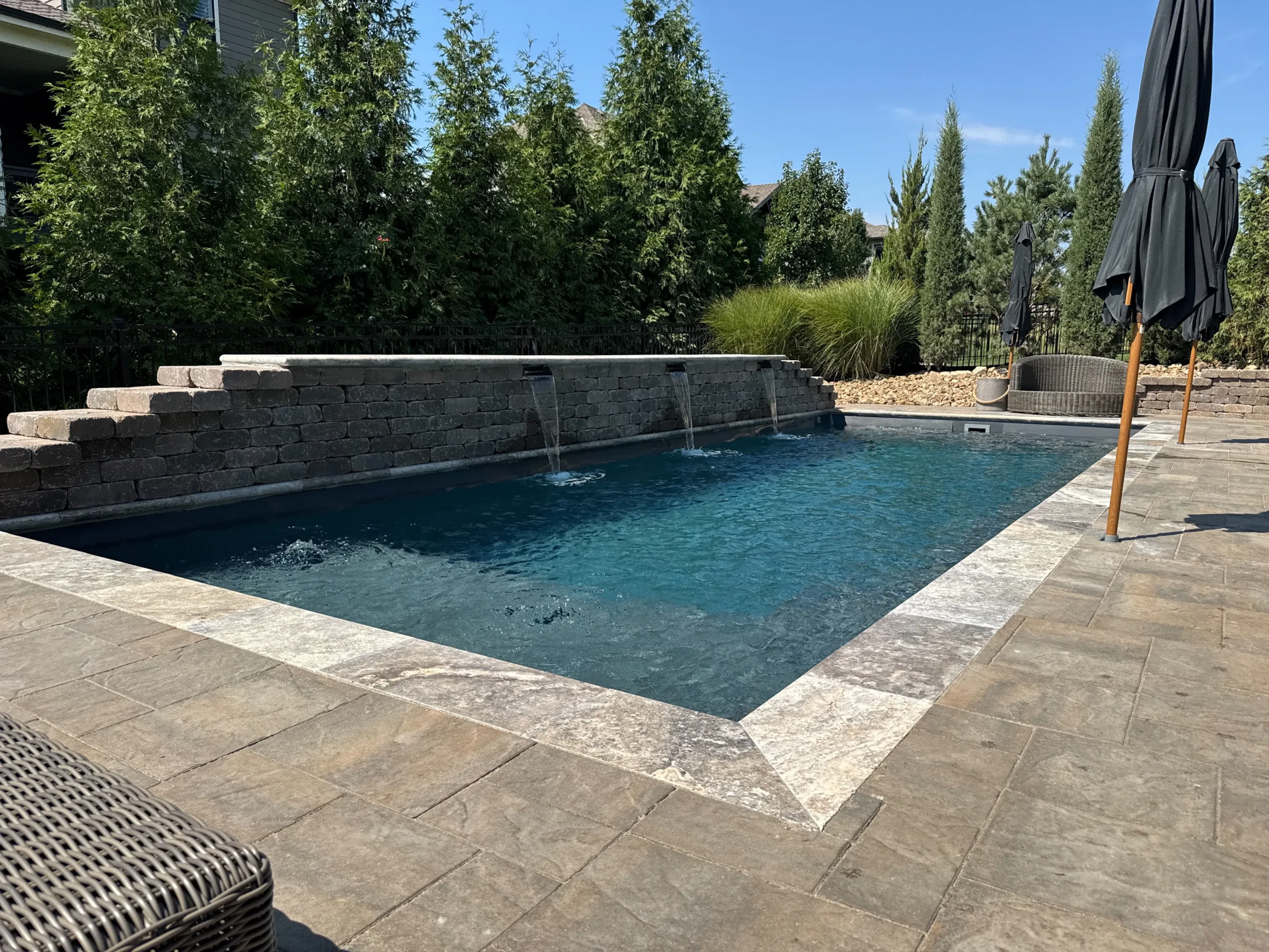 Fiberglass pool installation in Olathe Kansas showing completed coping and water features