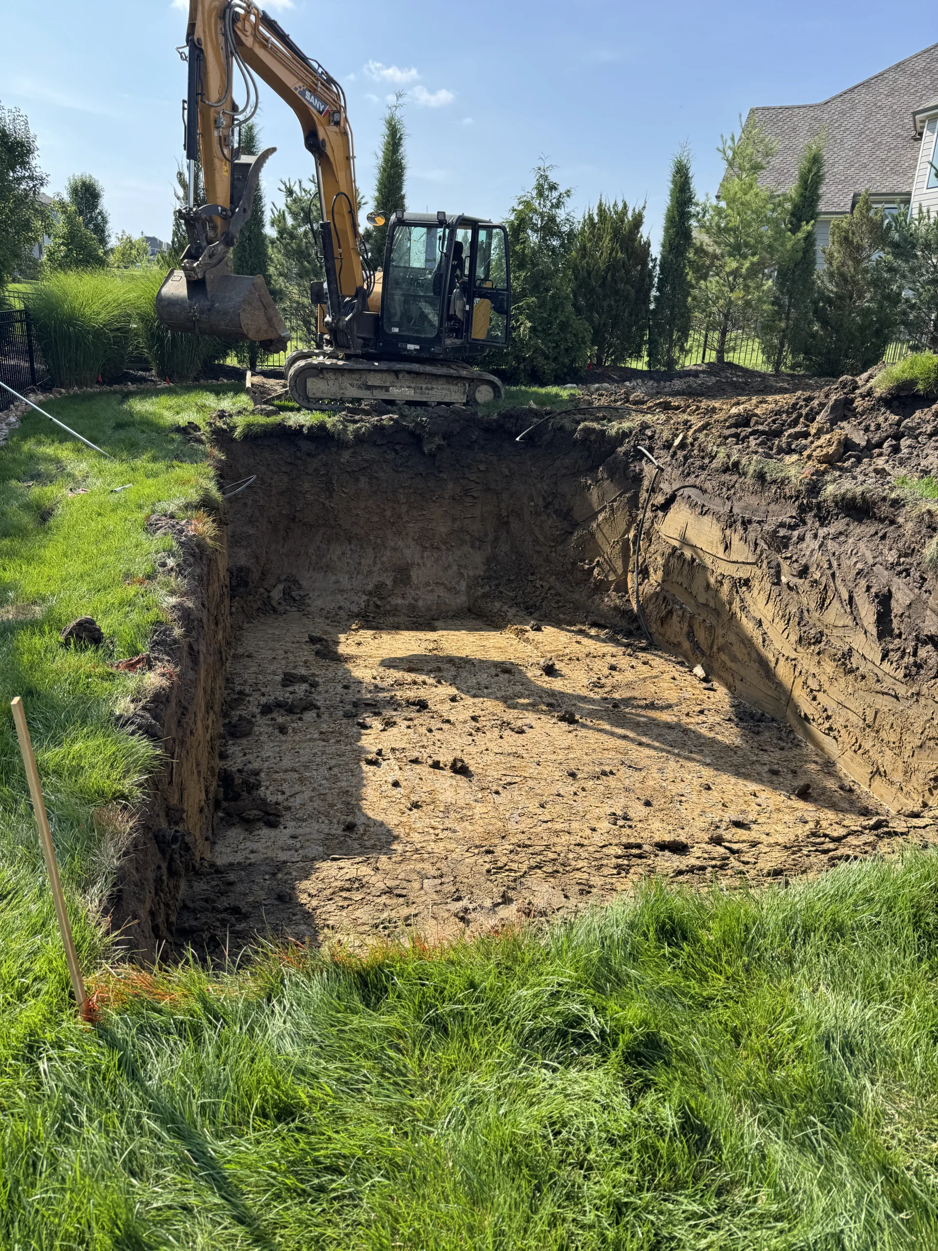 Pool excavation showing clay soil conditions during fiberglass pool installation in Johnson County Kansas